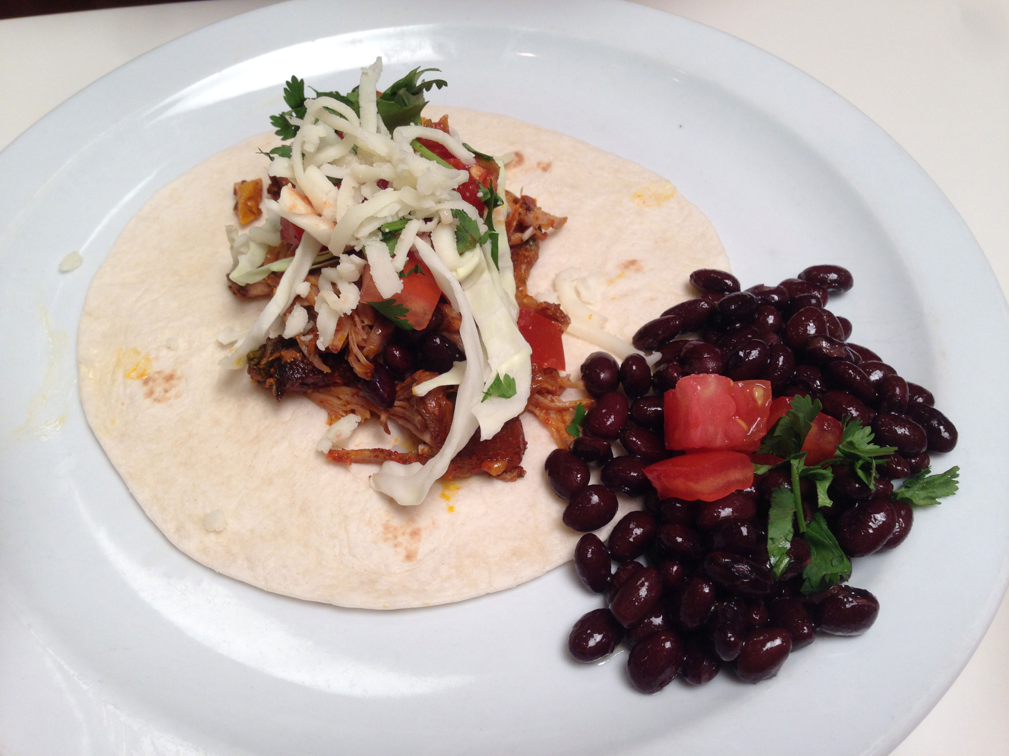 Pork shoulder, rubbed with Achiote paste (crushed seeds from the Annetto tree), slow simmered (8 hours) in fresh lime, lemon,  and orange juice with cilantro and garlic.
