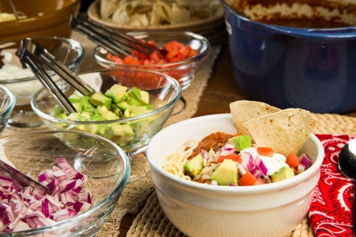Delicious slow-simmered chili, ladled over your favorite pasta, with an assortment of toppings, including shredded cheddar cheese, fresh chopped tomatoes, diced red onions, sour cream, ripe diced avocados and tortilla chips.