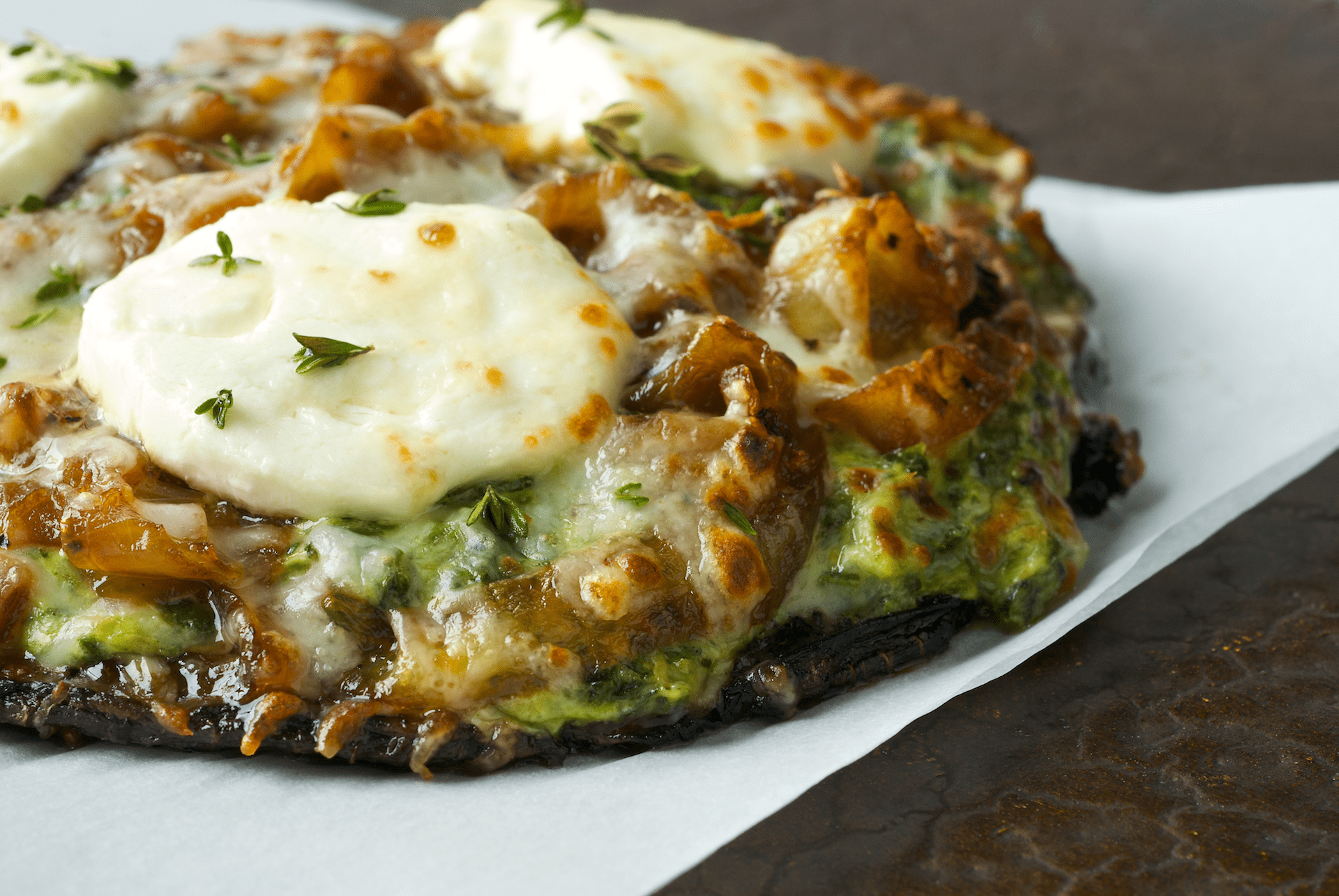 This vegetarian and crustless pizza is filled with tangry, creamy Chevre, prepared spinach and artichoke dip and seasoned with fresh thyme atop earthy Portobello mushrooms.