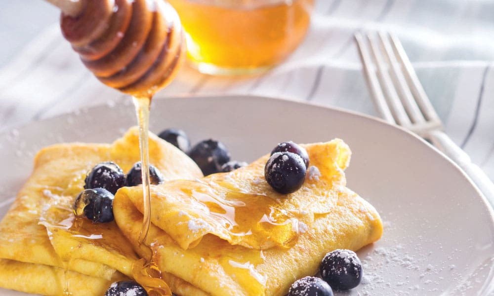 Photo of plated blueberry blintzes with honey, taken for the National Honey Board.
