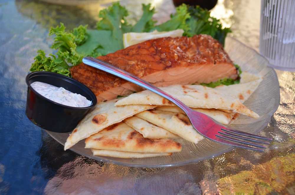 A plate of smoked fish served with pita bread.