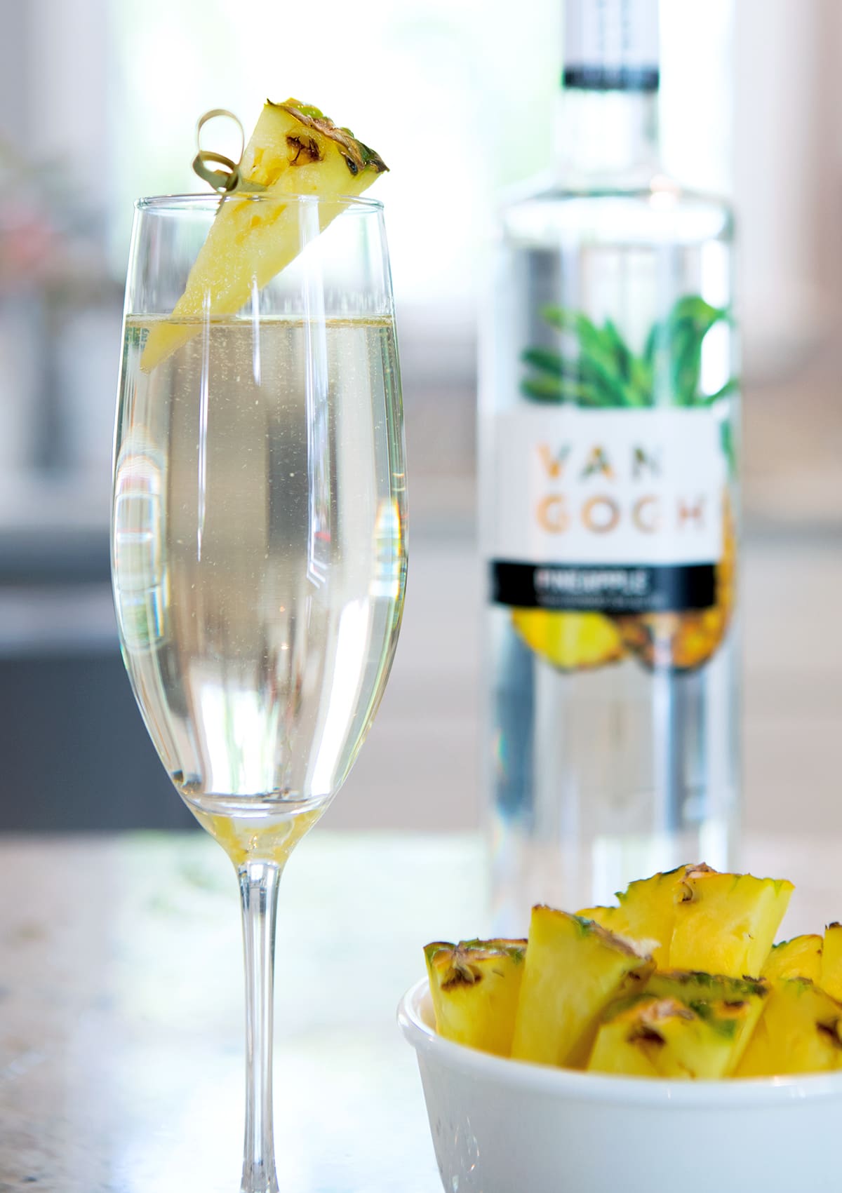 Add chilled pineapple vodka to a flute and top with chilled sparkling wine. Garnish with a. pineapple slice.