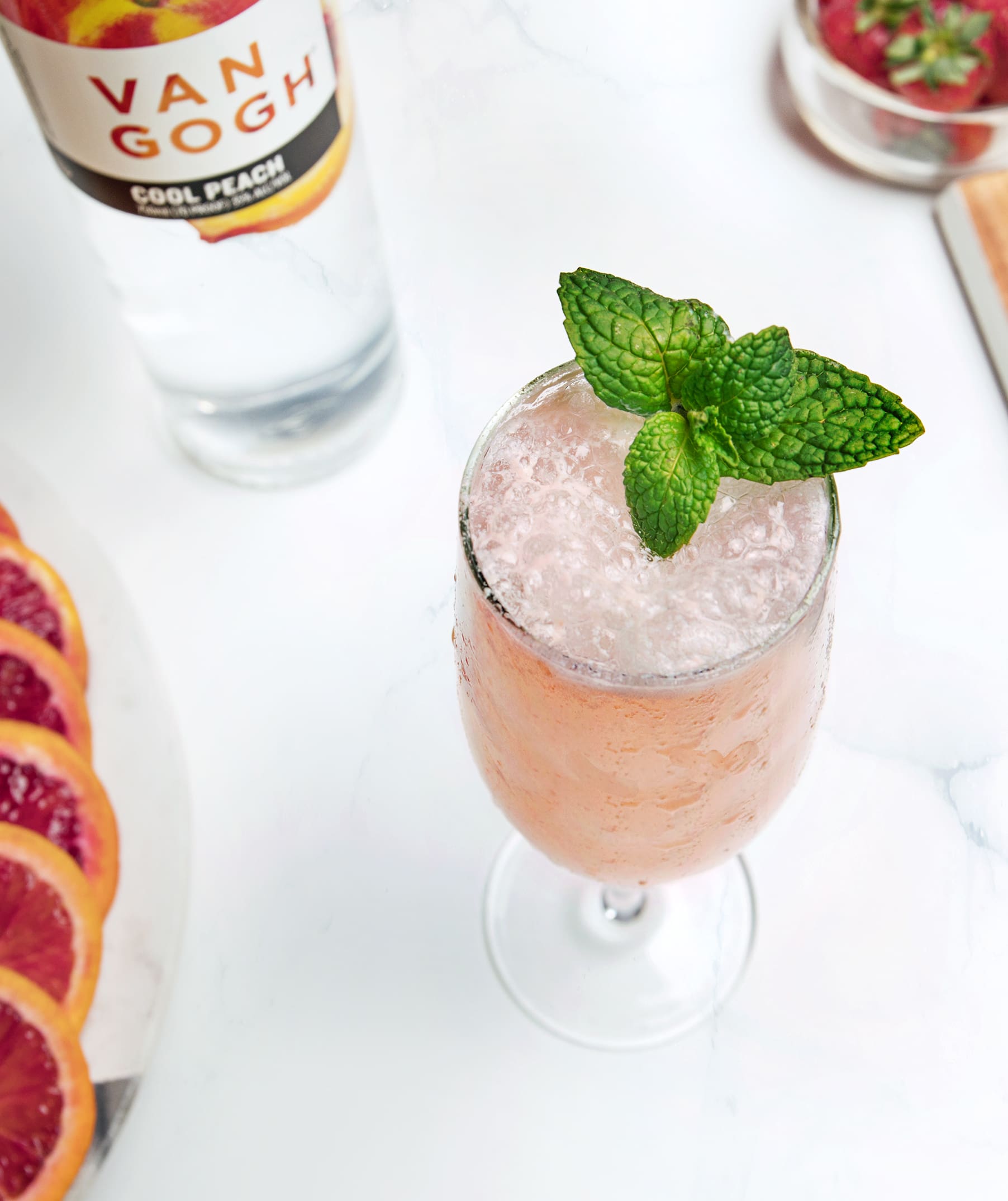 In a mixing glass, add ingredients with ice and gently fold together without over-stirring. Strain into a chilled flute. Garnish with a floating mint leaf and peach slice.