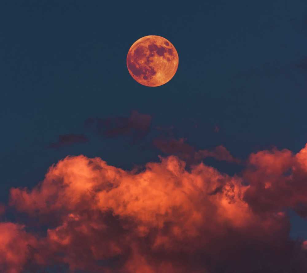 A full moon rises over a cloudy sky, the perfect setting for a Halloween celebration.