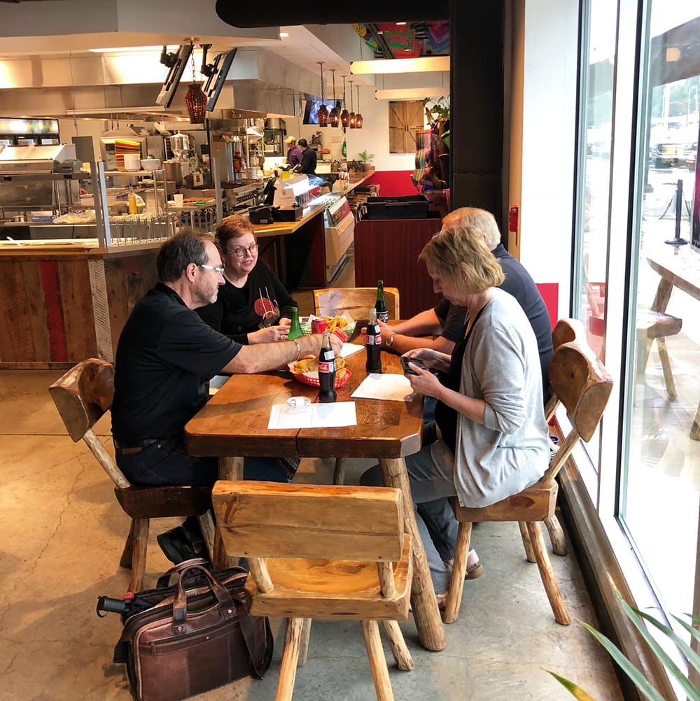 A group dining at one of the unique wood-carved tables at Yeyos Mexican Grill in the 8th Street Market in Bentonville, Arkansas.