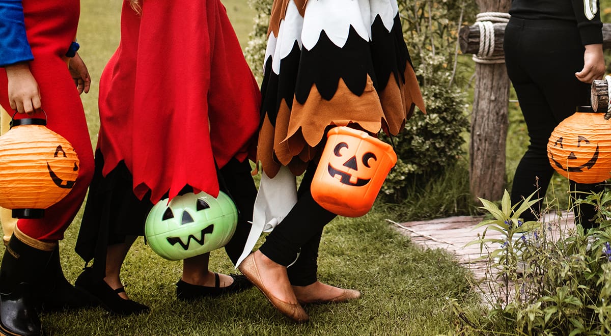 Children dressed in costumes going trick or treating for Halloween.