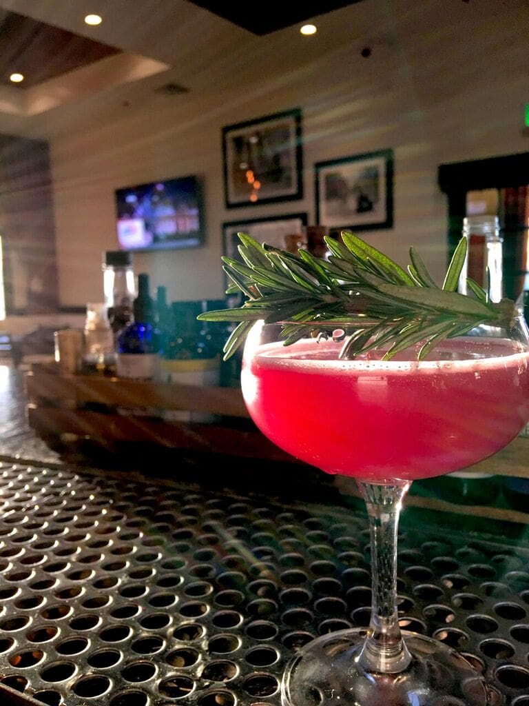 Combine all ingredients (except champagne) over ice, shake, and strain. Add champagne and garnish with sprig of rosemary.