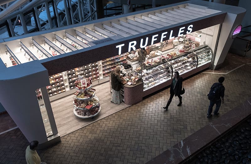 A truffle shop featuring an assortment of chocolate truffles for purchase.