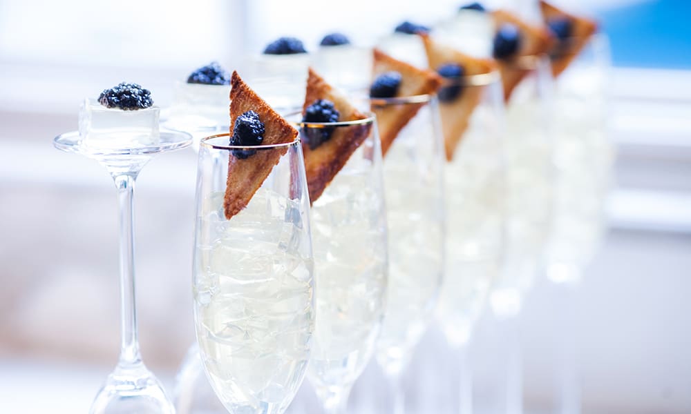 A row of champagne flute glasses with Jello caviar toast on the rims. Perfect for celebrating the Academy Awards.