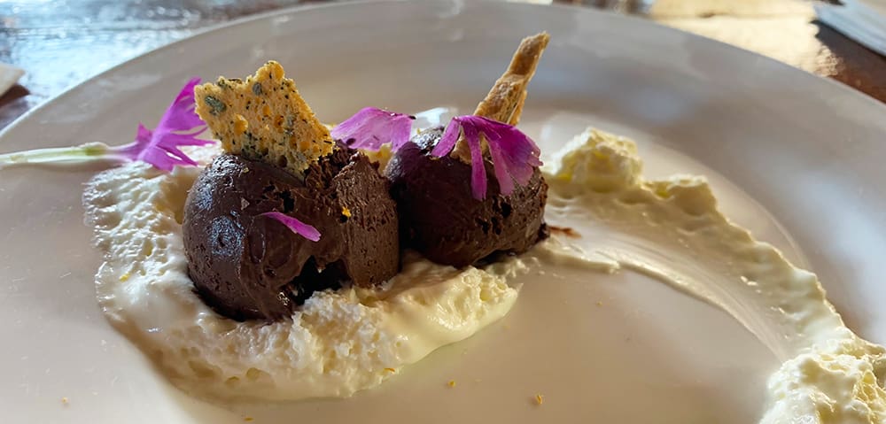 Topping the tour, and the evening, off was a refreshing Virgin Pina Colada, good conversation with our fellow tour participants, and a memorable dessert made of dark chocolate and Kaua’i coffee mousse, topped with whipped cream made with almond extract and orange zest, plus dianthus edible flowers and a small piece of Absinthe biscotti crowning the final creation.